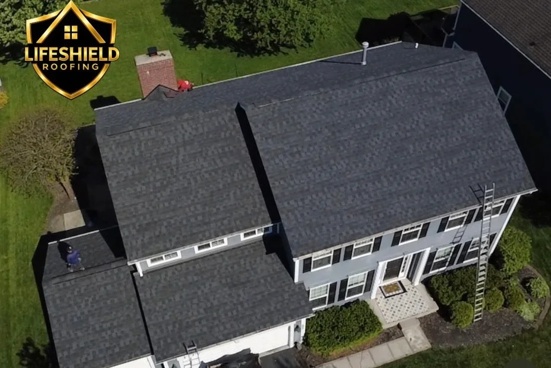 Aerial view of residential home with new charcoal gray asphalt shingle roof installation on multiple slopes