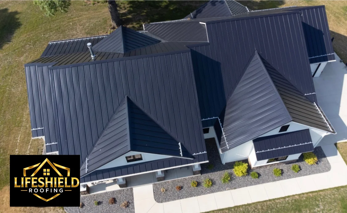 Aerial view of dark gray standing seam metal roof installation with multiple peaks and valleys